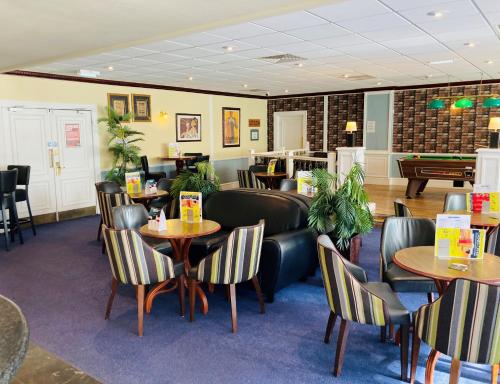 a restaurant with tables and chairs and a pool table at Britannia Hotel Newcastle Airport in Newcastle upon Tyne