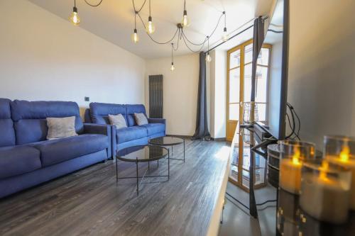 uma sala de estar com um sofá azul e uma mesa em 2 bd apartment with sauna in the center of Annecy em Annecy