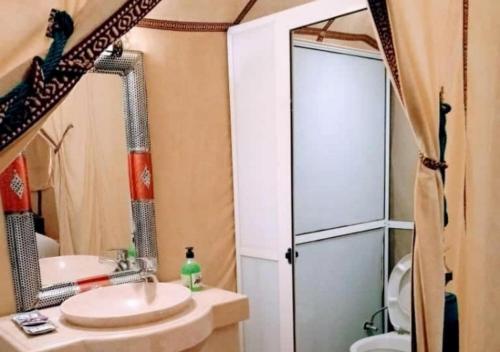 a bathroom with a shower and a sink and a mirror at Fantastic Luxury Camp in Merzouga