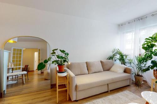 ein Wohnzimmer mit Sofa und einigen Pflanzen in der Unterkunft Le Bucolique - appart 1 chambre in Annecy