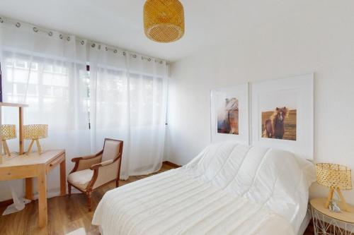 ein weißes Schlafzimmer mit einem Bett und einem Schreibtisch in der Unterkunft Le Bucolique - appart 1 chambre in Annecy