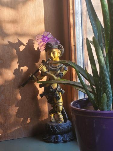a figurine with a flower on its head next to a plant at Purple Papillon in Heuvelland