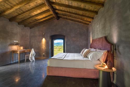 a bedroom with a bed and a desk in a room at Dimora Cottanera in Castiglione di Sicilia