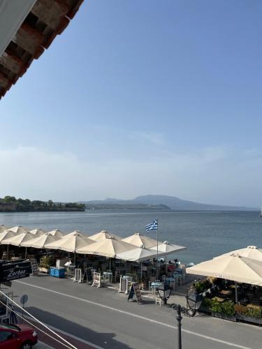 a group of umbrellas and tables and the water at KORONI MARE FRONT HARBOR in Koroni
