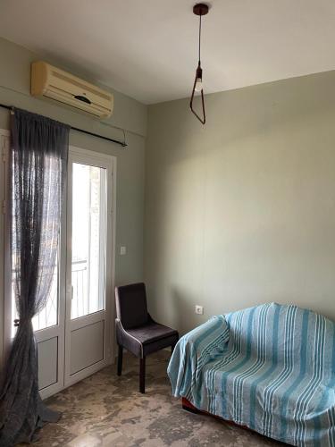 a bedroom with a bed and a chair and a window at KORONI MARE FRONT HARBOR in Koroni