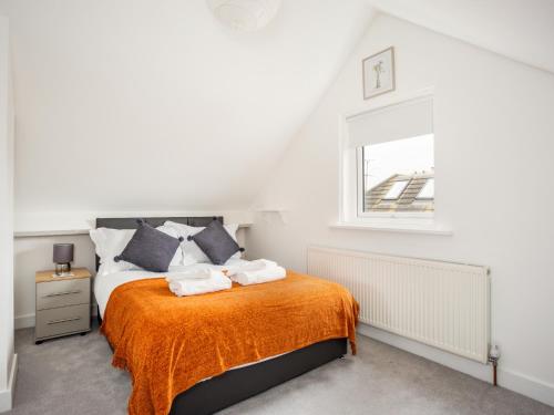 a bedroom with a bed with an orange blanket at Outstanding 6 Sleeper - Great Location - Legoland in Windsor