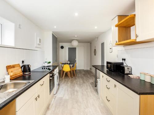 a kitchen with white cabinets and black counter tops at Outstanding 6 Sleeper - Great Location - Legoland in Windsor