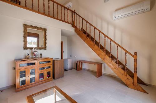 a hallway with a wooden staircase and a mirror at Villa Rose in Kolimbia