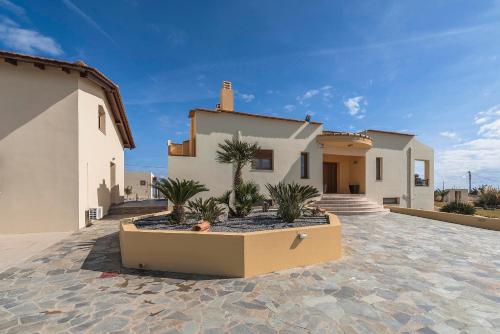 a house with potted plants in front of it at Villa Rose in Kolimbia