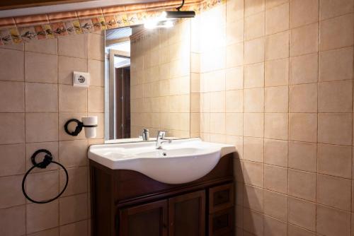 uma casa de banho com um lavatório branco e um espelho. em CASA DON ALEJANDRO y DOÑA FLORENCIA em Hornachuelos