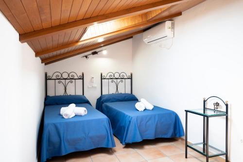 2 camas en una habitación con sábanas azules en CASA DON ALEJANDRO y DOÑA FLORENCIA, en Hornachuelos