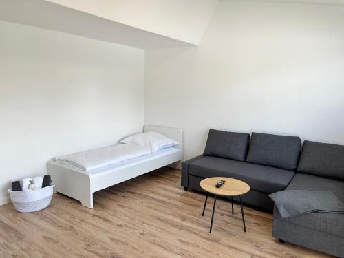 uma sala de estar com um sofá e uma cama em Premium Apartment 70qm 2 Zimmer Küche, Balkon, Smart TV, WiFi em Aalen