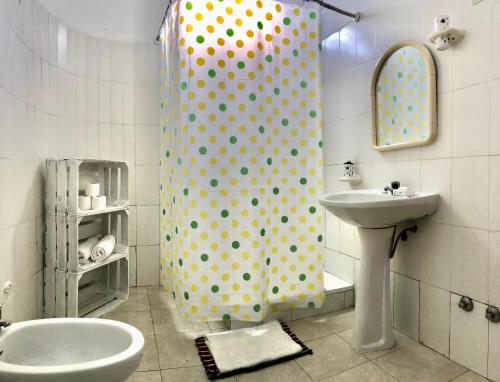 a bathroom with a polka dot shower curtain and a sink at Tarrafal Ecodécor Full House in Tarrafal