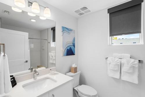 a bathroom with a sink and a toilet and a mirror at Ocean Club Treasure Island Hotel in St Pete Beach