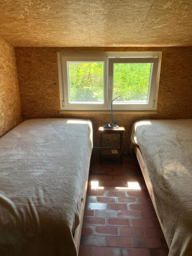 um quarto com duas camas e um candeeiro sobre uma mesa em Pivert em Auvernier