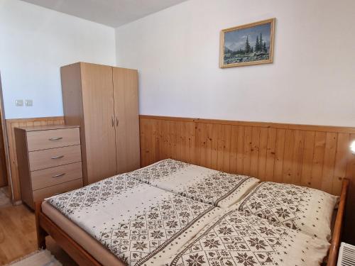 a small bedroom with a bed and a dresser at Apartmány Lýdia in Zuberec