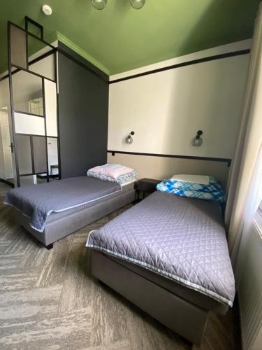 Zimmer mit 2 Betten und einem Spiegel in der Unterkunft Zespół Placówek Oświatowych - Bursa in Łańcut