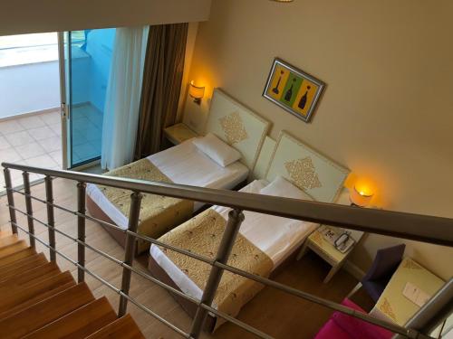 a room with two beds and a balcony at Crystal Admiral Resort Suites & Spa - Ultimate All Inclusive in Kızılot