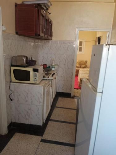 una cucina con forno a microonde e frigorifero di appartement au centre ville a Beni Mellal
