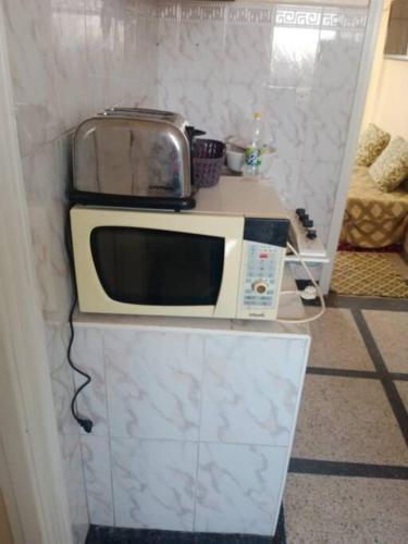 un forno a microonde seduto sopra un bancone di appartement au centre ville a Beni Mellal