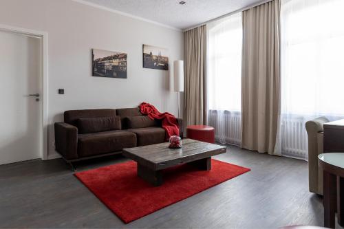 a living room with a brown couch and a red rug at Hotel Garni " Am Domplatz" in Erfurt