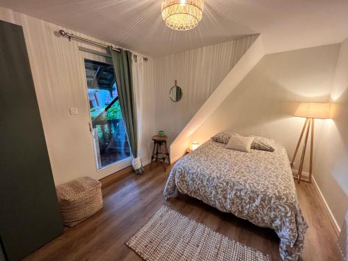 a bedroom with a bed and a window at Appartement dans un corps de ferme alsacien in Mittelhausbergen