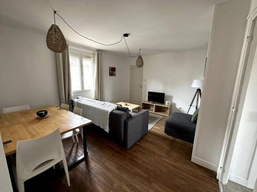 ein Wohnzimmer mit einem Sofa und einem Tisch in der Unterkunft François Mitterrand 2 in Elbeuf