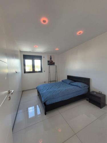 a bedroom with a bed in a white room at Cocon zen et confortable à proximité de Colmar in Sundhoffen