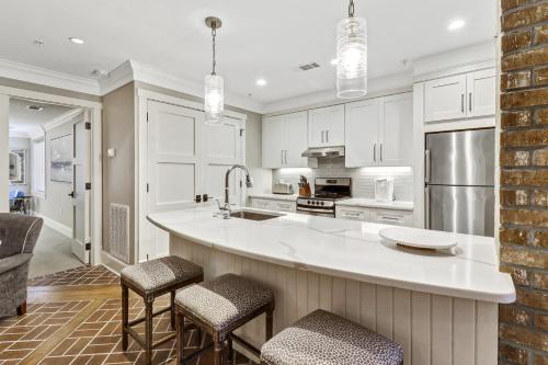 a kitchen with white cabinets and a large island with bar stools at 103 Seacrest in Hilton Head Island