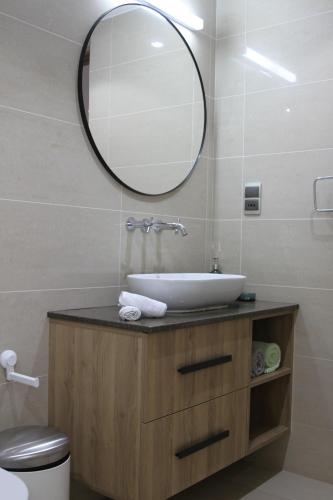 ein Bad mit einem Waschbecken und einem Spiegel in der Unterkunft Belle Vue Lodge in Victoria