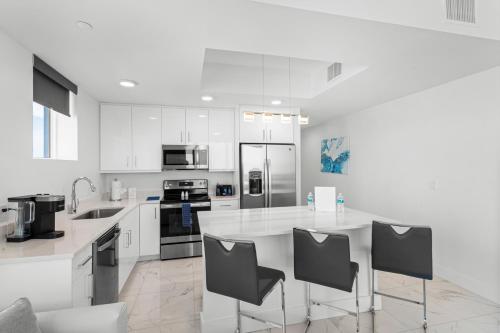 a kitchen with white cabinets and a counter with chairs at Ocean Club Treasure Island Hotel in St Pete Beach
