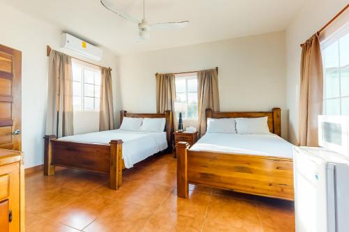 two beds in a room with two windows at Isebei Guest House Gold Standard Certified in Hopkins