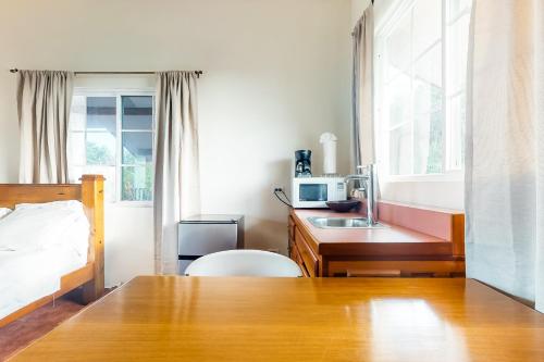a bedroom with a bed and a desk with a microwave at Isebei Guest House Gold Standard Certified in Hopkins
