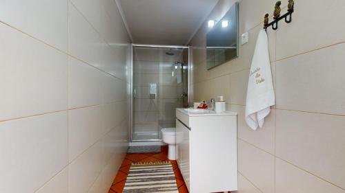 a white bathroom with a shower and a toilet at Azores Furnas Quinta Do Vale in Furnas