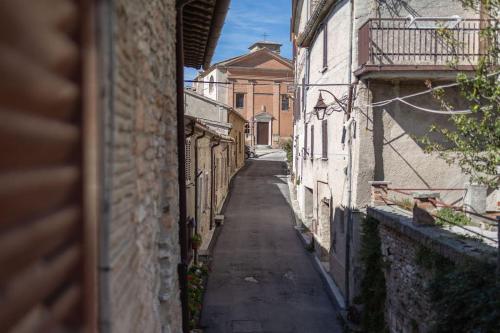 eine Gasse zwischen zwei Gebäuden mit einem Gebäude in der Unterkunft La casetta di fossato in Fossato di Vico