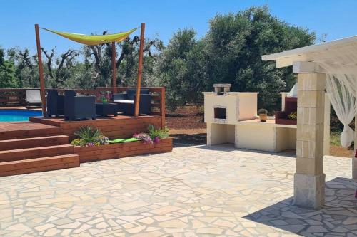 a patio with a hammock next to a pool at villa Antony in San Michele Salentino