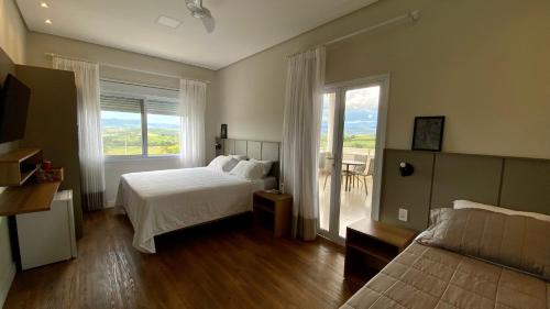 サン・ジョアン・バチスタ・ド・グローリアにあるPousada Vila Craton Canastraのベッドルーム1室(ベッド1台、景色を望む窓付)