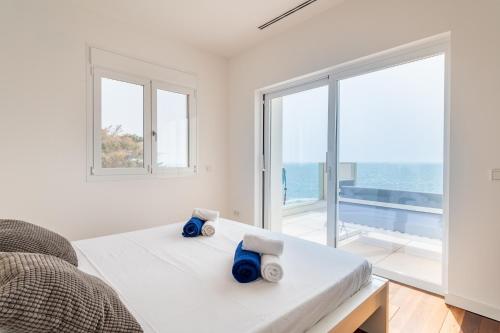 Dormitorio blanco con cama y ventana grande en Villa Mediterraneo by Mallorca House Rent, en Cala Murada