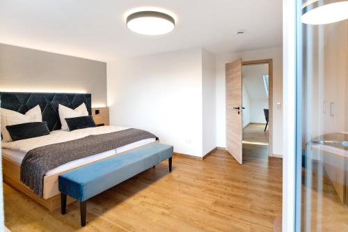 a bedroom with a large bed with a blue bench at Kaiserchalet in Höchenschwand