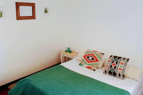 1 dormitorio con 1 cama con manta verde en Departamento a 60 mts de la estación de Banfield en Banfield