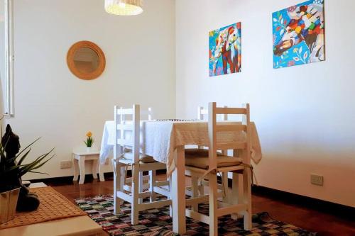 a white dining room with a table and chairs at Departamento a 60 mts de la estación de Banfield in Banfield