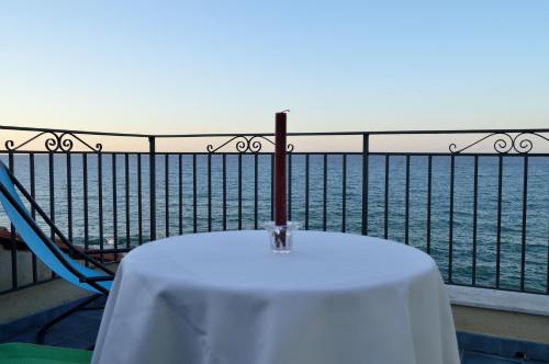 a table and a chair on a balcony overlooking the water at MiraMare Residence Cefalú in Cefalù