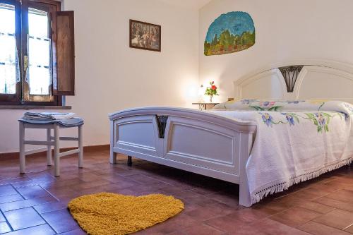 a bedroom with a white bed and a yellow rug at La Casanuova in Laiatico
