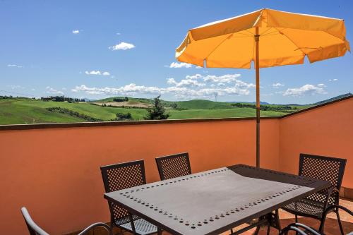 a table with an umbrella and chairs on a balcony at La Casanuova in Laiatico