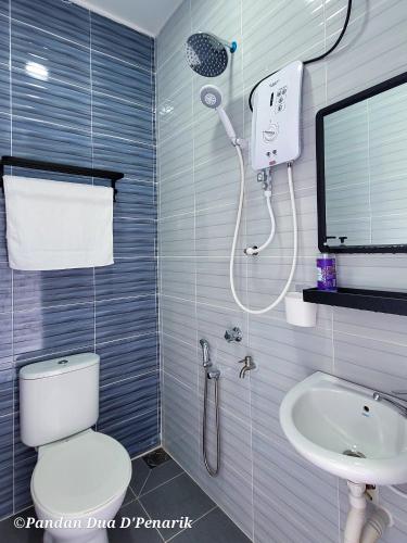 a bathroom with a shower and a toilet and a sink at Pandan Dua D'Penarik in Kampong Ru Sepuloh