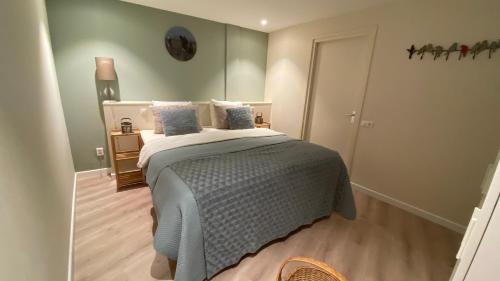 a bedroom with a bed with a gray blanket and pillows at BNB In het centrum van Enkhuizen in Enkhuizen