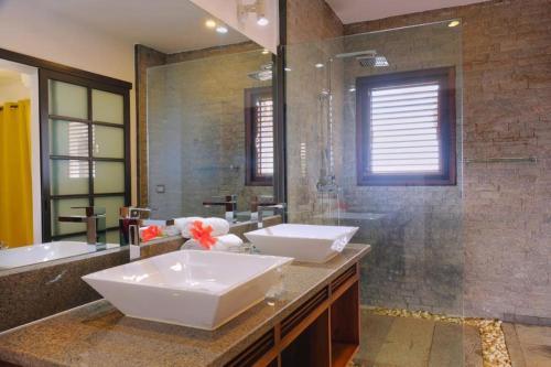 een badkamer met 2 wastafels en een douche bij ANJARA LODGE Studio 1 chambre in Nosy Be