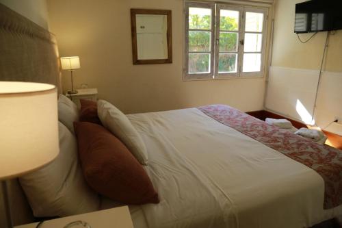 a bedroom with a large white bed with a window at La Masia in Chacras de Coria