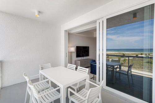 a dining room with a table and chairs and a view of the ocean at Ocean Club Treasure Island Hotel in St Pete Beach