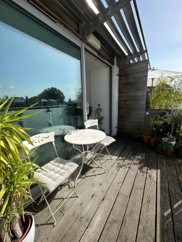 a patio with a table and chairs on a deck at Bright and airy Islington apartment in London